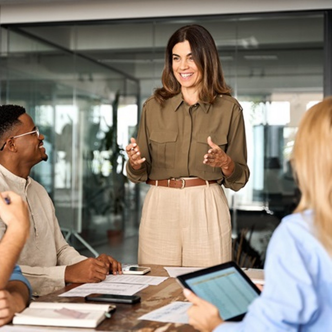 Eine lächelnde Geschäftsfrau leitet eine Präsentation für ihr Team