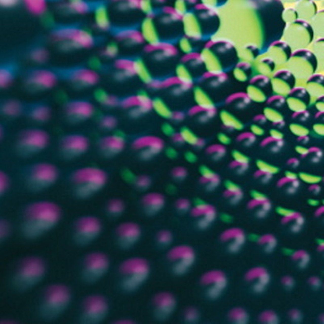 Eine molekülartige Struktur aus Kugeln wird von lila und grünem Licht beleuchtet